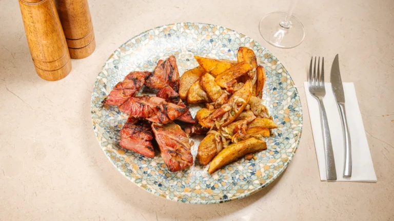 Ceafă de porc afumată & cartofi țărănești – ceafă de porc afumată, cartofi, ulei de floarea soarelui, ceapă. Preparat servit la Restaurant Intim din Focșani