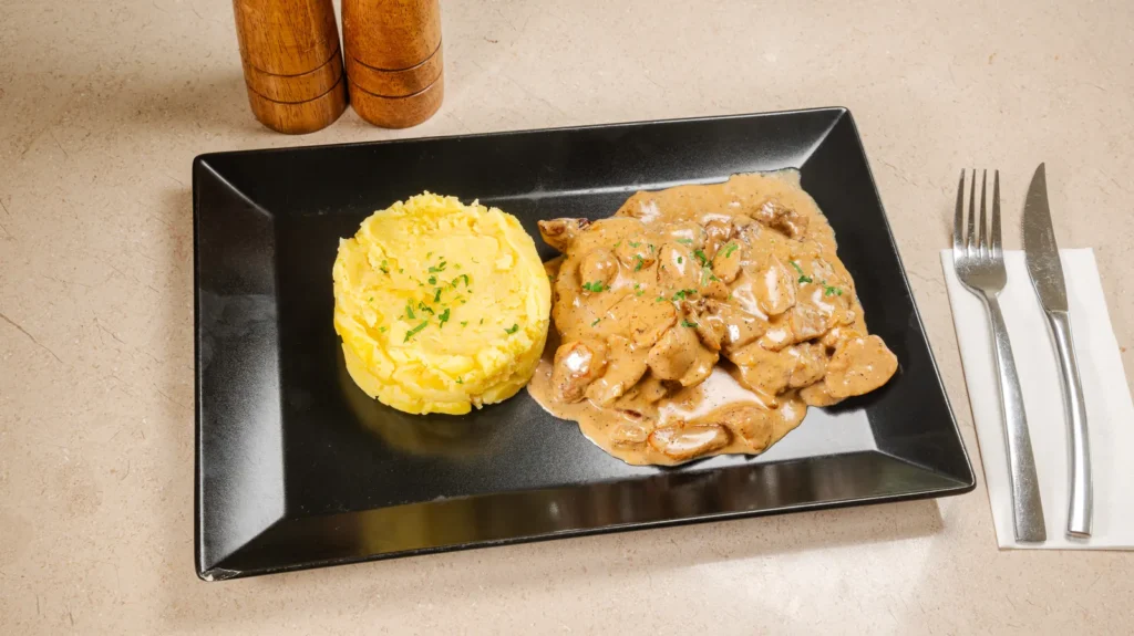 Mușchiuleț de porc cu sos de hribi & piure – mușchiuleț de porc, piure de cartofi, cremă vegetală UHT de gătit, ulei de floarea soarelui. Preparat servit la Restaurant Intim din Focșani