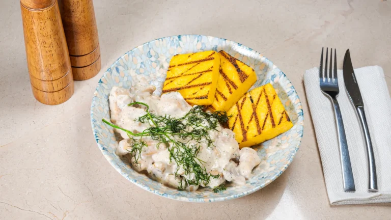 Piept de pui cu smântână & ciuperci cu mămăligă – piept de pui, cremă vegetală UHT de gătit, ciuperci, usturoi. Preparat servit la Restaurant Intim din Focșani