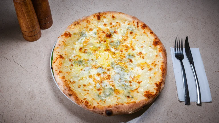 Pizza Quattro Formaggi – aluat dospit 24h, mozzarella, gorgonzola, cașcaval afumat. Preparat servit la Restaurant Intim din Focșani