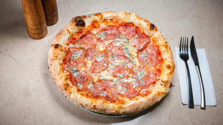 Pizza Salami e Gorgonzolla – aluat dospit 24h, sos de roșii, mozzarella, salam picant / salam dulce. Preparat servit la Restaurant Intim din Focșani