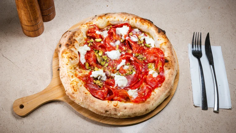 Pizza Vesuvio – aluat dospit 24h, sos de roșii, mozzarella, salam ventricina. Preparat servit la Restaurant Intim din Focșani