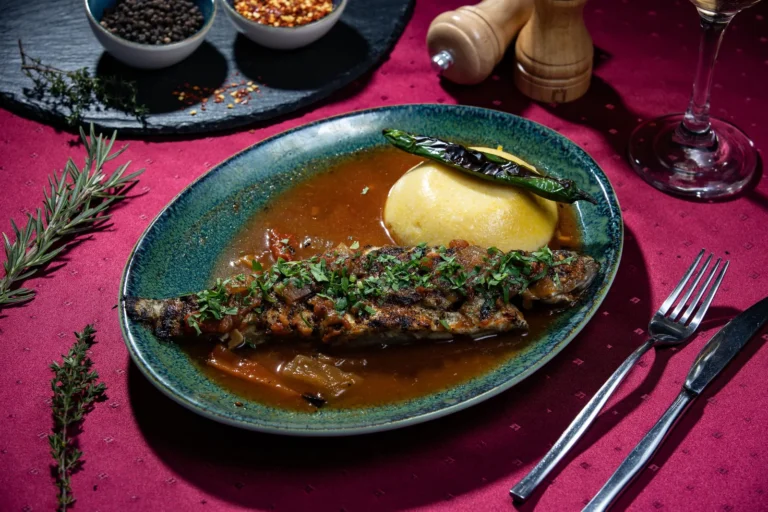 Saramură de păstrăv / Păstrăv la grătar – păstrăv, saramură de legume, mămăligă, mujdei. Preparat servit la Restaurant Intim din Focșani