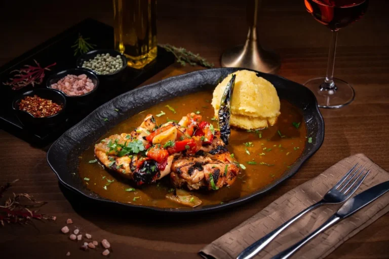 Saramură de pui cu mămăligă coaptă – piept de pui, pulpă de pui, ardei gras, roșii. Preparat servit la Restaurant Intim din Focșani