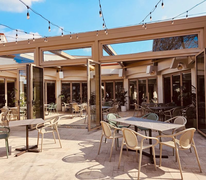 Terasa Restaurantului Intim, cu mese în aer liber și instalație de lumini